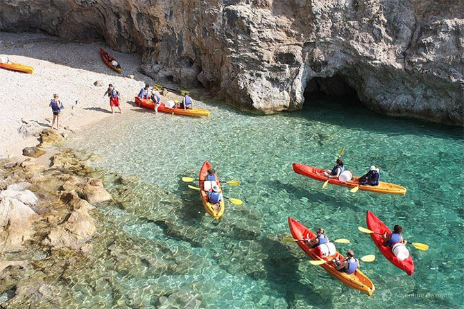 Grupo de personas remando en kayaks hacia la Cova Tallada"] en la costa de Dénia durante una excursión guiada por Kayak Tours Dénia.